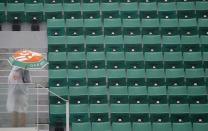 Tennis - French Open - Roland Garros- Paris, France - 30/05/16. A man uses an umbrella at the central court as rain falls in Paris. REUTERS/Pascal Rossignol