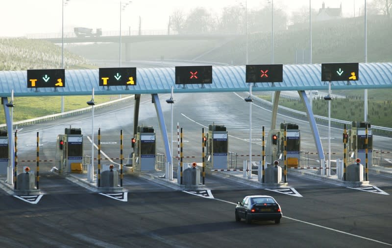 A motorist approaches toll booths on the new M6 Toll motorway near Birmingham in northern England, December 9, 2003. REUTERS/Andrew Fox