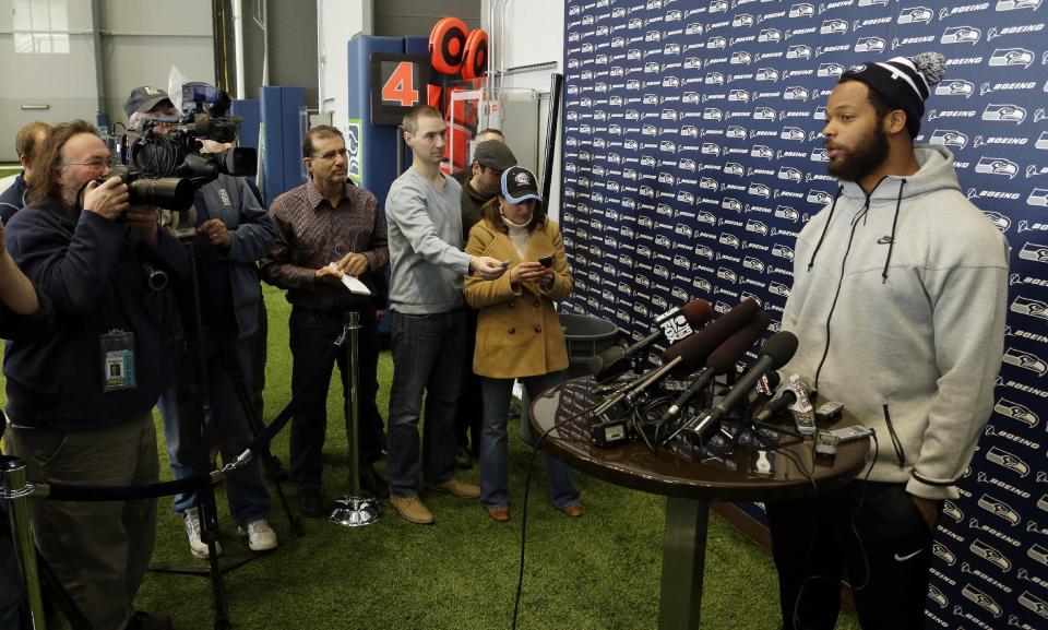 Seattle Seahawks defensive end Michael Bennett, right, talks to reporters, Monday, March 10, 2014, at the team's headquarters in Renton, Wash. The Seahawks announced Monday that Bennett, who was one of the top NFL football free agents this year, had signed a multi-year deal with the Super Bowl champion Seahawks. (AP Photo/Ted S. Warren)