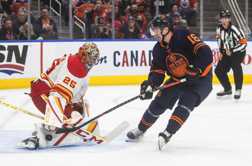 Calgary Flames goalie Jacob Markstrom (25) makes a save on Edmonton Oilers' Zach Hyman (18) during the second period of an NHL hockey game Saturday, Oct. 16, 2021, in Edmonton, Alberta. (Jason Franson/The Canadian Press via AP)