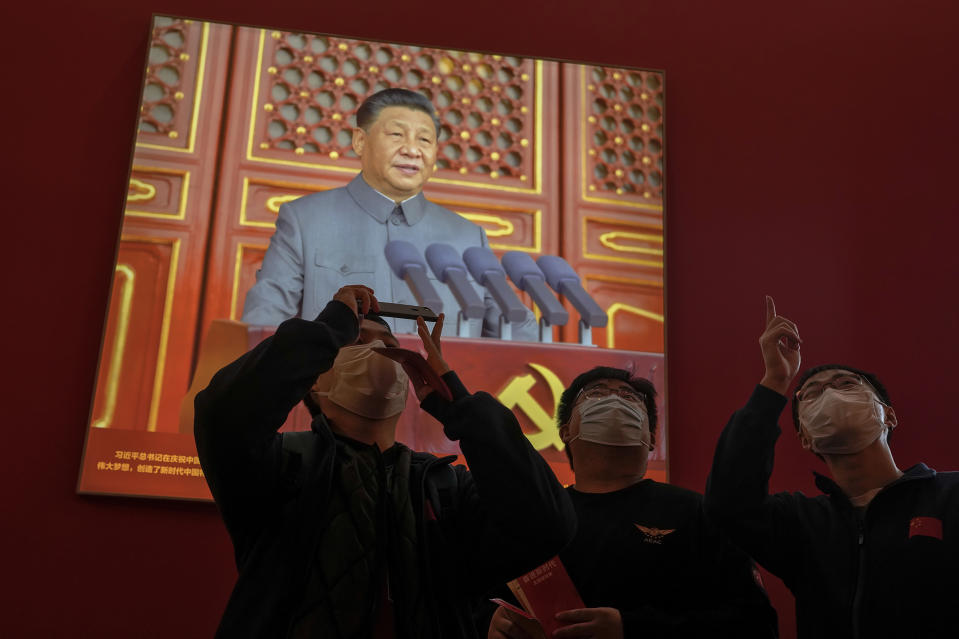 FILE- Visitors wearing face masks stand watch in front of a screen showing Chinese President Xi Jinping at an exhibition highlighting Xi and China's achievements under his leadership at the Beijing Exhibition Hall in the capital city where the 20th Party Congress will be held in Beijing on Oct. 12, 2022. When Xi Jinping came to power in 2012, it wasn't clear what kind of leader he would be. His low-key persona during a steady rise through the ranks of the Communist Party gave no hint that he would evolve into one of modern China's most dominant leaders, or that he would put the economically and militarily ascendant country on a collision course with the U.S.-led international order. (AP Photo/Andy Wong, File)