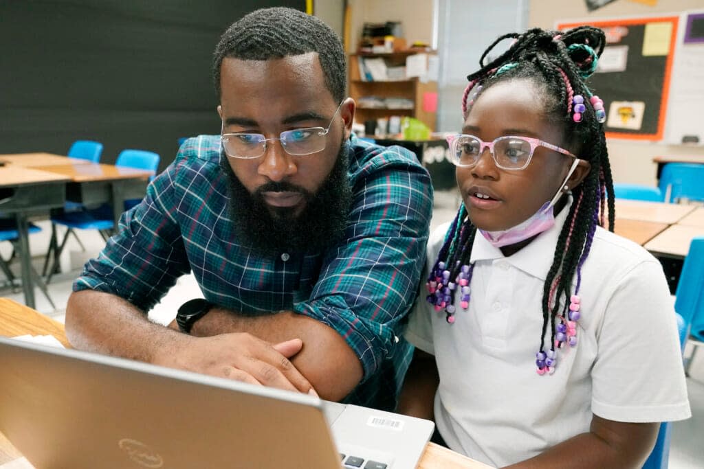 Ryan Johnson, a fifth-grade teacher at Pecan Park Elementary School, left, checks to see what homework his daughter, Rylei, is bringing home, as they prepare to leave Johnson’s classroom in Jackson, Miss., Tuesday, Sept. 6, 2022. (AP Photo/Rogelio V. Solis)