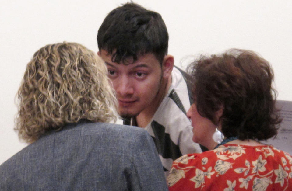 FILE - In this Thursday, Jan. 24, 2019, file photo Wilber Ernesto Martinez-Guzman, of El Salvador, listens to his public defender and interpreter during his initial appearance in Carson City Justice Court, in Carson City, Nev. The Nevada Supreme Court struck down a deadline Friday, April 9, 2021, that a district judge set later this month for the Salvadoran immigrant's lawyers to file a motion claiming he's intellectually disabled and therefore can't be executed if convicted of murdering a Reno couple and two other woman. (AP Photo/Scott Sonner, File)