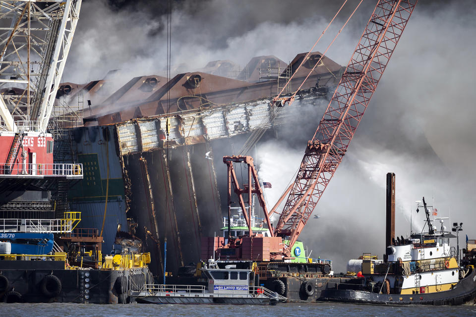 Fire fighters spray water into the cut away mid-section of the cargo vessel Golden Ray, Friday, May 14, 2021, Brunswick, Ga. The Golden Ray had roughly 4,200 vehicles in its cargo decks when it capsized off St. Simons Island on Sept. 8, 2019. Crews have used a giant gantry crane to carve the ship into eight giant chunks, then carry each section away by barge. (AP Photo/Stephen B. Morton)