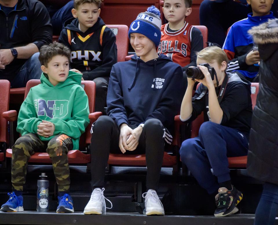 Dylan Langholf, in Colts cap, son of Peoria Notre Dame girls basketball coach Layne Langholf, has a laugh while watching player introductions before the start of the PND-Lincoln game Saturday, Jan. 20, 2024 at Renaissance Coliseum in Peoria.