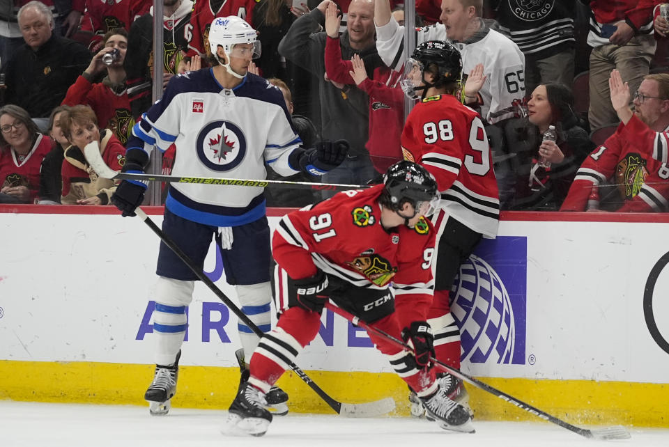 Winnipeg Jets defenseman Brenden Dillon, left, and Chicago Blackhawks center Connor Bedard (98) get into it during the third period of an NHL hockey game Friday, Feb. 23, 2024, in Chicago. (AP Photo/Erin Hooley)