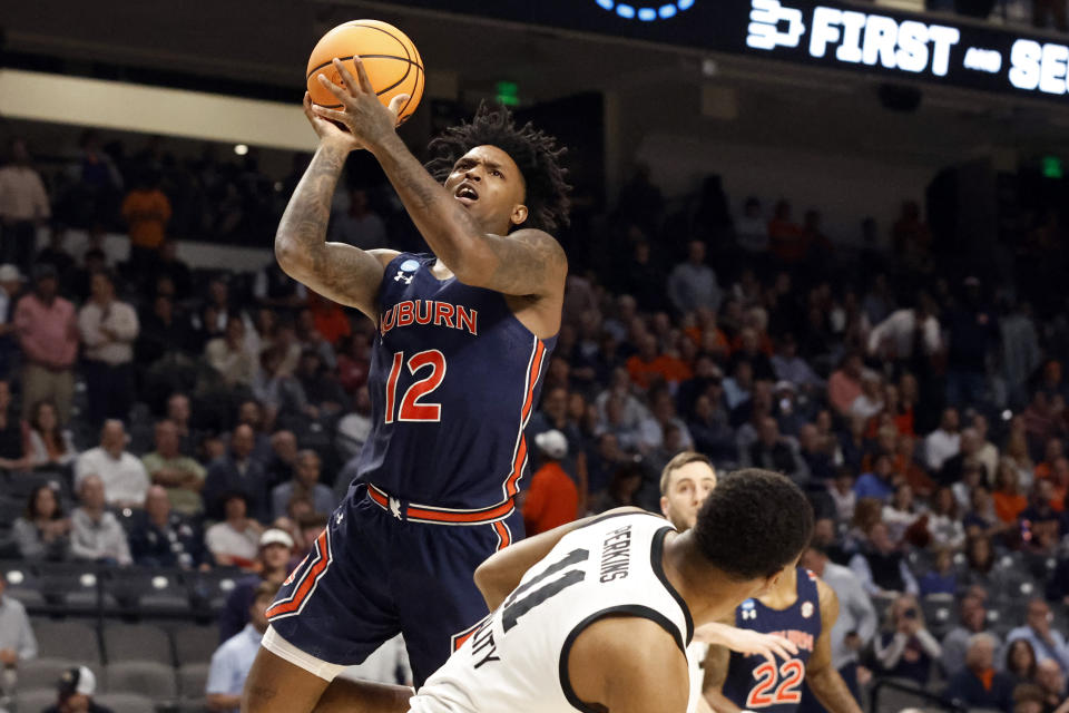 Auburn guard Zep Jasper (12) shoots next to Iowa guard Tony Perkins (11) during the first half of a first-round college basketball game in the men's NCAA Tournament in Birmingham, Ala., Thursday, March 16, 2023. (AP Photo/Butch Dill)