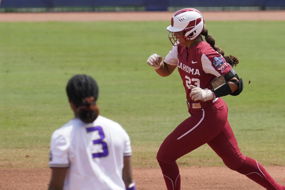 Oklahoma's Tiare Jennings, right, runs past James Madison pitcher Odicci Alexander (3) with a home run in the first inning of an NCAA Women's College World Series softball game Sunday, June 6, 2021, in Oklahoma City. (AP Photo/Sue Ogrocki)