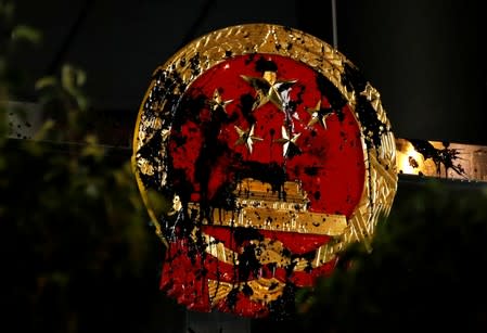 FILE PHOTO: The National Emblem of the People's Republic of China is seen vandalised on the Chinese Liaison Office after a march to call for democratic reforms, in Hong Kong, China