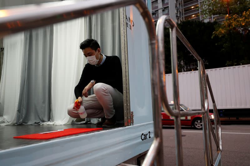 Curriculum officer Evan Kam cleans a mobile piano classroom before a piano class, on Ming’s Piano truck, following the novel coronavirus disease (COVID-19) outbreak, in Hong Kong