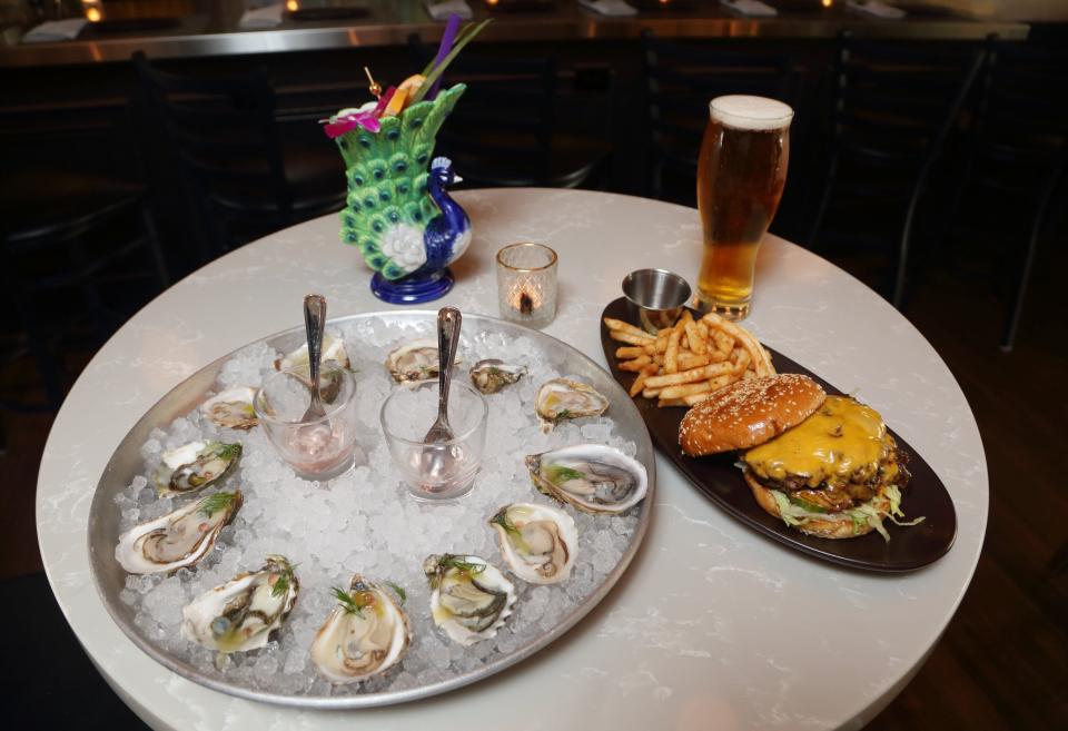 Oysters on the half shell, a Proud as a Peacock drink, an OKC (Oklahoma City) double smash burger and one of the 20 beers on tap are on display June 14 at the Worthington Tavern.