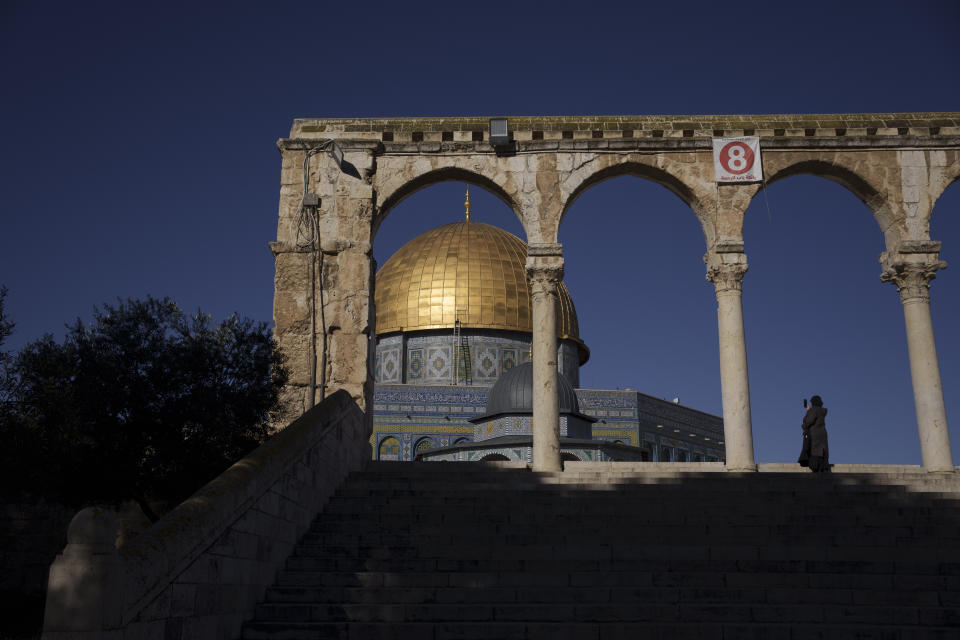 A Muslim woman uses her phone to take a picture of the Dome of the Rock shrine, at the Al Aqsa Mosque compound in the Old City of Jerusalem, Thursday, Feb. 29, 2024. (AP Photo/Leo Correa)