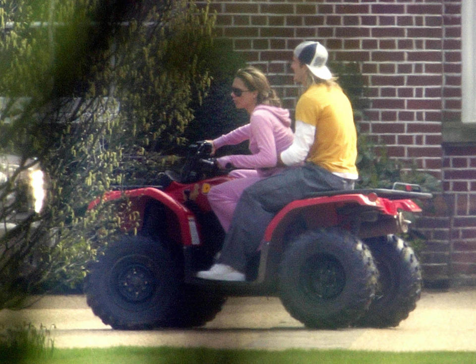 David Beckham (L) and his wife Victoria ride on a quadbike at their Hertfordshire home, 12 April 2004. (Odd Andersen / AFP via Getty Images)