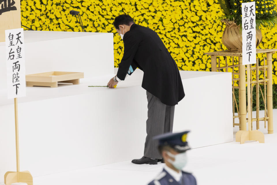 Japan's Prime Minister Fumio Kishida lays a flower during a memorial service marking the 77th anniversary of Japan's World War II defeat, at the Nippon Budokan hall in Tokyo, Monday, Aug. 15, 2022. (Yuichi Yamazaki/Pool Photo via AP)