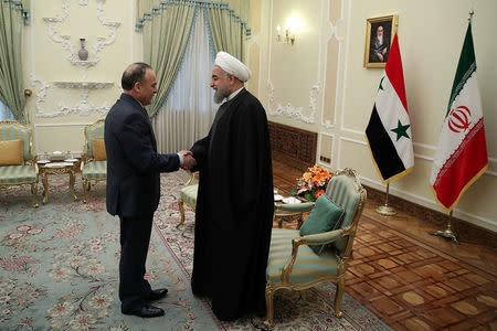 Iran's President Hassan Rouhani shakes hands with Syrian Prime Minister Emad Khamis in Tehran, Iran January 18, 2017. Picture taken January 18, 2017. President.ir/Handout via REUTERS