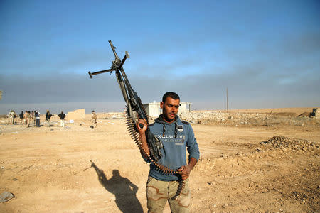 A member of the Iraqi Army walks during clashes with Islamic State militants at the south of Mosul, Iraq December 12, 2016.REUTERS/Ammar Awad