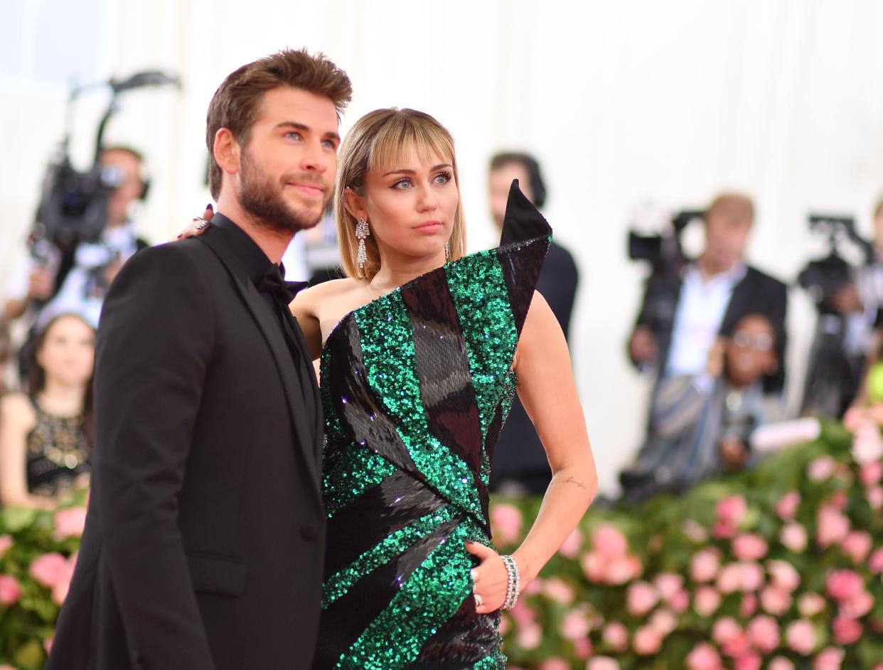 Miley Cyrus (R) and Liam Hemsworth arrive for the 2019 Met Gala at the Metropolitan Museum of Art on May 6, 2019, in New York. - The Gala raises money for the Metropolitan Museum of Arts Costume Institute. The Gala's 2019 theme is Camp: Notes on Fashion" inspired by Susan Sontag's 1964 essay "Notes on Camp". (Photo by ANGELA  WEISS / AFP)        (Photo credit should read ANGELA  WEISS/AFP/Getty Images)