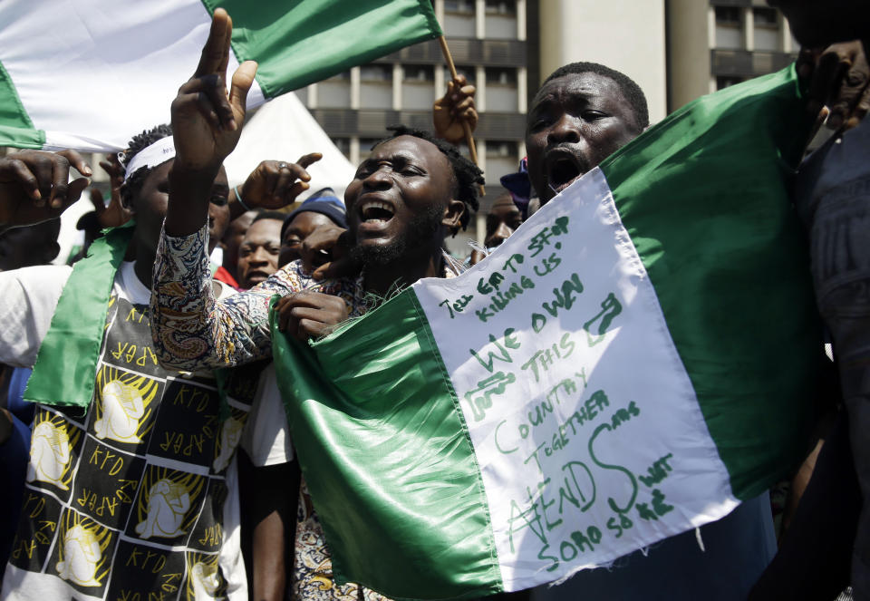 FILE - People hold banners as they demonstrate on the street to protest against police brutality, in Lagos, Nigeria, on Oct. 20, 2020. In a report submitted to Lagos Governor Babajide Sanwo-Olu on Monday, Nov. 15, 2021, a Nigerian judicial panel has found that soldiers of the Nigerian army "shot, injured and killed" protesters during the Oct. 2020 nationwide demonstrations against police brutality in the country's most populous city Lagos. (AP Photo/Sunday Alamba, File)