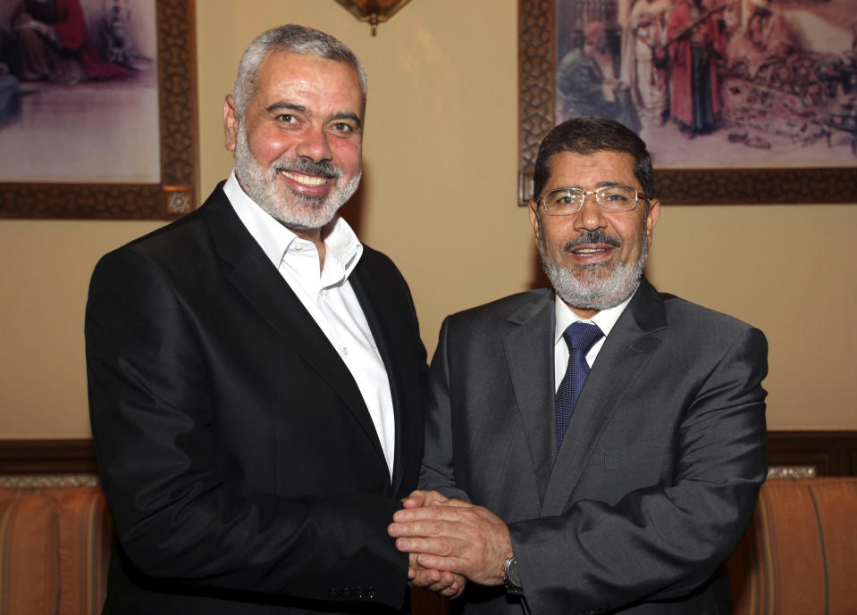 FILE -- In this Thursday, July 26, 2012 file photograph, released by Hamas, Egyptian President Mohammed Morsi, right, meets the Hamas Prime Minister of Gaza, Ismail Haniyeh in Cairo, Egypt. An Egyptian court ruled on Tuesday, March 4, 2014 to ban activities of the Palestinian militant group Hamas in Egypt in a move likely to fuel tension between Cairo's military-backed government and the Islamic group that rules the neighboring Gaza Strip. Egypt's interim leaders maintain that Hamas is playing a key role in the insurgency by militants in the northern region of the Sinai Peninsula, which borders Hamas-ruled Gaza and Israel. (AP Photo/Hamas, Mohamedf al-Ostaz, File)