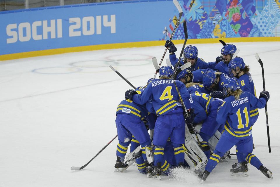 Team Sweden celebrates their 4-2 win over Finland in the 2014 Winter Olympics women's ice hockey quarterfinal game at Shayba Arena, Saturday, Feb. 15, 2014, in Sochi, Russia. (AP Photo/Matt Slocum)