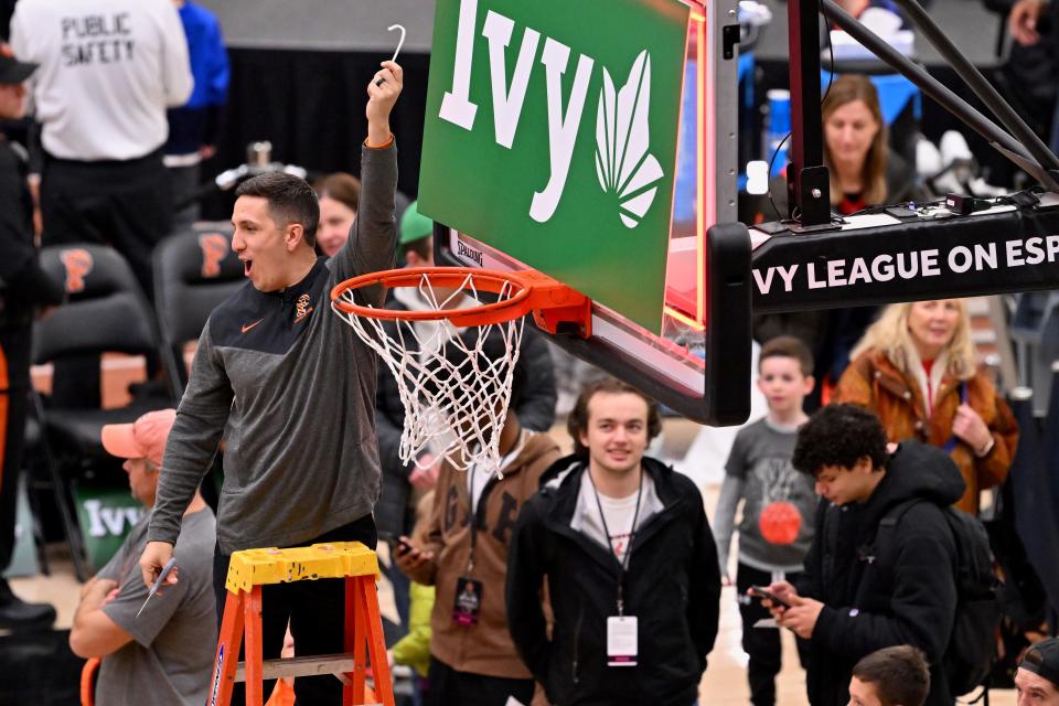 Chris Mongilia holds up a piece of the net after Princeton won the Ivy League Basketball Tournament.