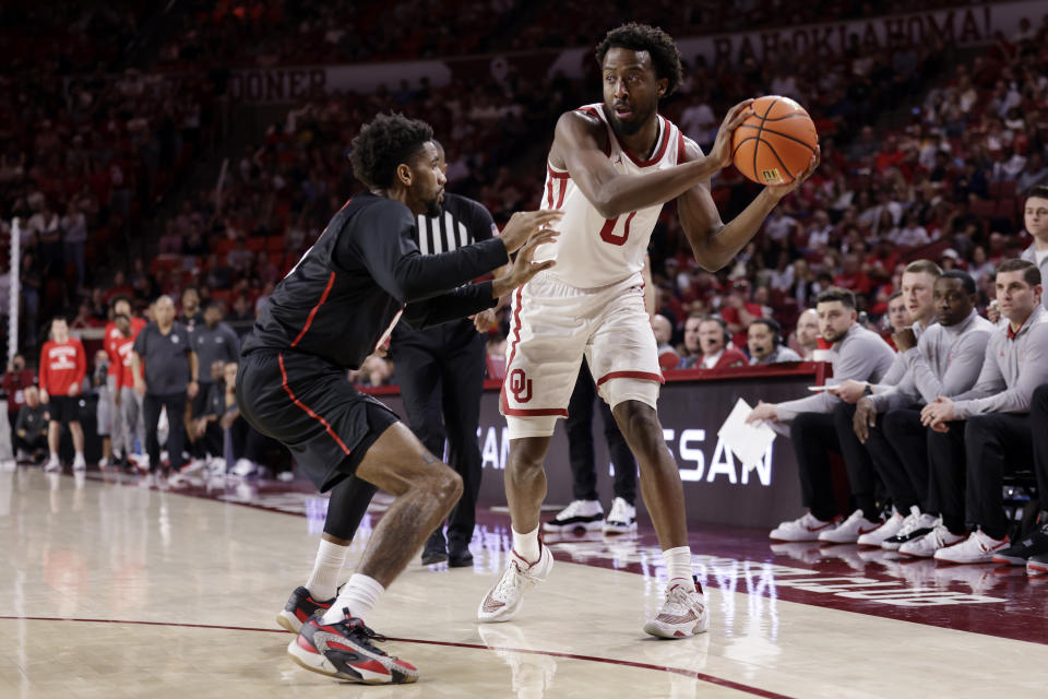 Oklahoma guard Le'Tre Darthard (0) protects the ball from Houston guard Mylik Wilson during the second half of an NCAA college basketball game Saturday, March 2, 2024, in Norman, Okla. (AP Photo/Garett Fisbeck)