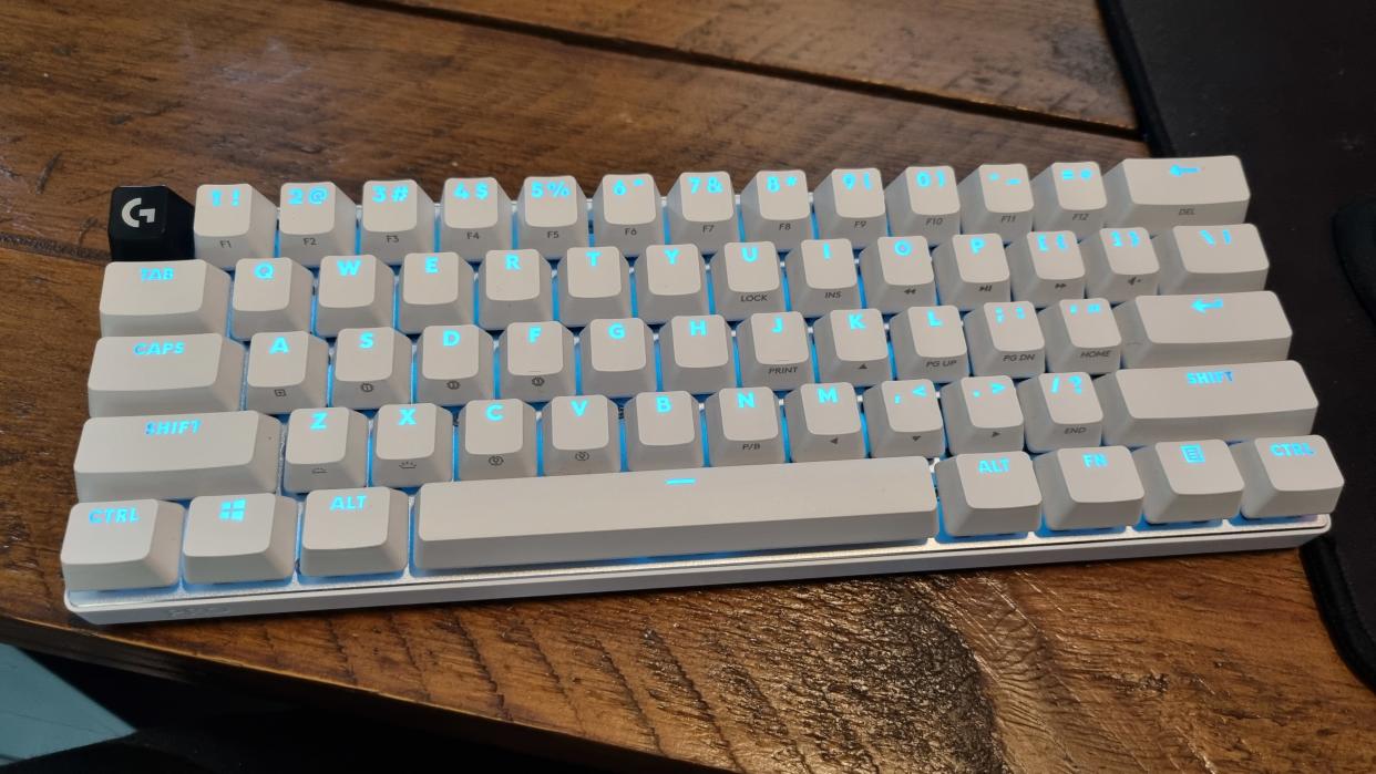  The Logitech Pro X60 keyboard, lit up in blue, on a wooden desk. 