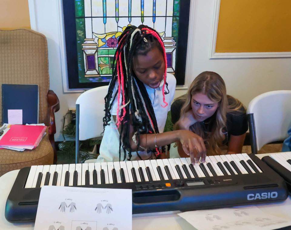 Grace Morrison, right, watches as Tyesha Demery plays a sequence of notes during DUETkids piano lessons at Central Missionary Baptist Church in Hitch Village.