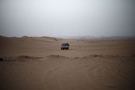 A vehicle transporting a group of African migrants drives through the desert on their journey from Ghat in southwest Libya May 29, 2014.REUTERS/Ahmed Jadallah