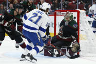 Tampa Bay Lightning center Brayden Point (21) scores a goal against Arizona Coyotes goaltender Antti Raanta, right, as Coyotes defenseman Niklas Hjalmarsson (4) watches during the second period of an NHL hockey game Saturday, Feb. 22, 2020, in Glendale, Ariz. (AP Photo/Ross D. Franklin)