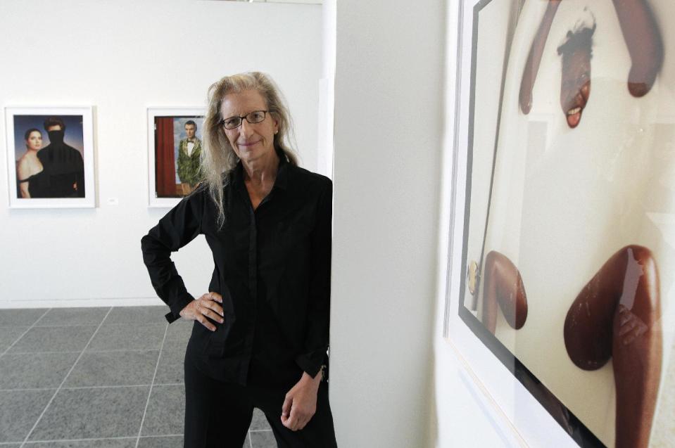 Annie Leibovitz stands near some of her work before the opening of her exhibition at the Wexner Center for the Arts Friday, Sept. 21, 2012, in Columbus, Ohio. Leibovitz's exhibition features work from her “Master Set,” an authoritative edition of 156 images. (AP Photo/Jay LaPrete)