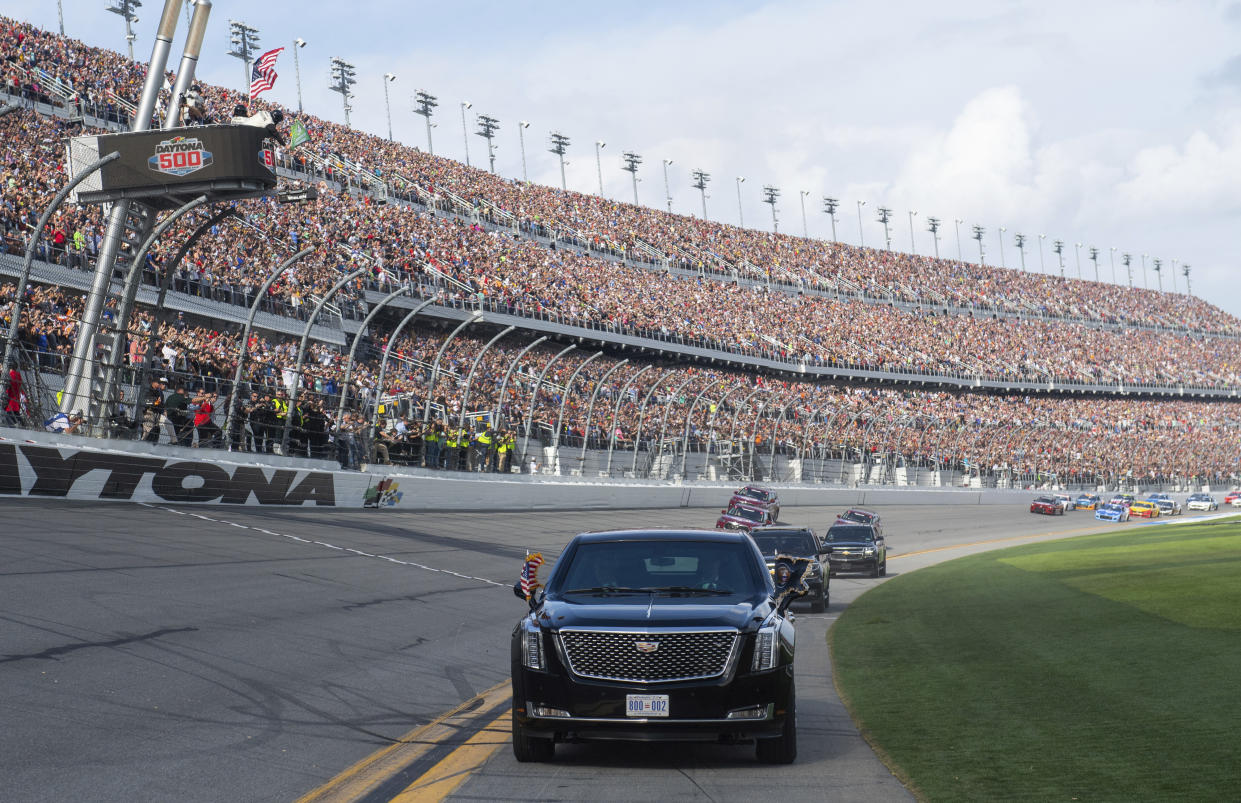 President Donald Trump and first lady Melania Trump ride in the presidential limousine as they take a pace lap ahead of the start of the NASCAR Daytona 500 auto race at Daytona International Speedway in Daytona Beach, Fla., Sunday, Feb. 16, 2020. (Saul Loeb/Pool Photo via AP)