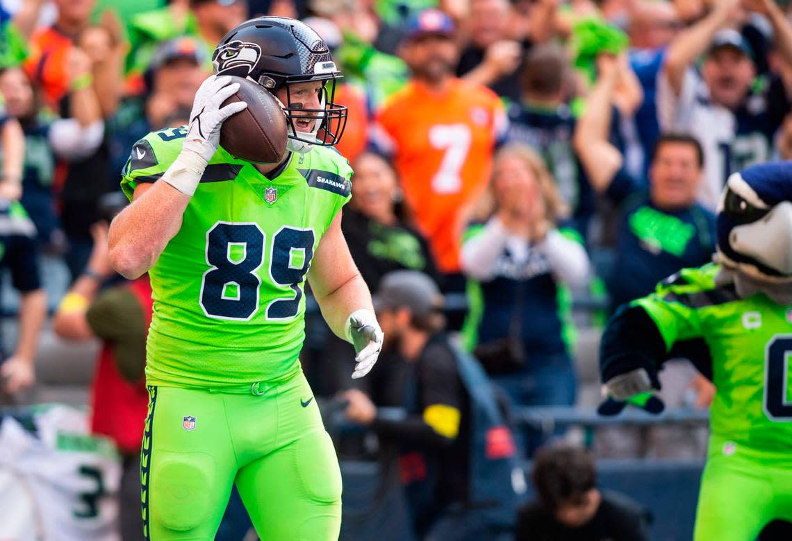 Seattle Seahawks tight end Will Dissly (89) holds the ball to his ear as he celebrates in the end zone after scoring the first touchdown of the game in the first quarter of an NFL game on Monday, Sept. 12, 2022, at Lumen Field in Seattle.