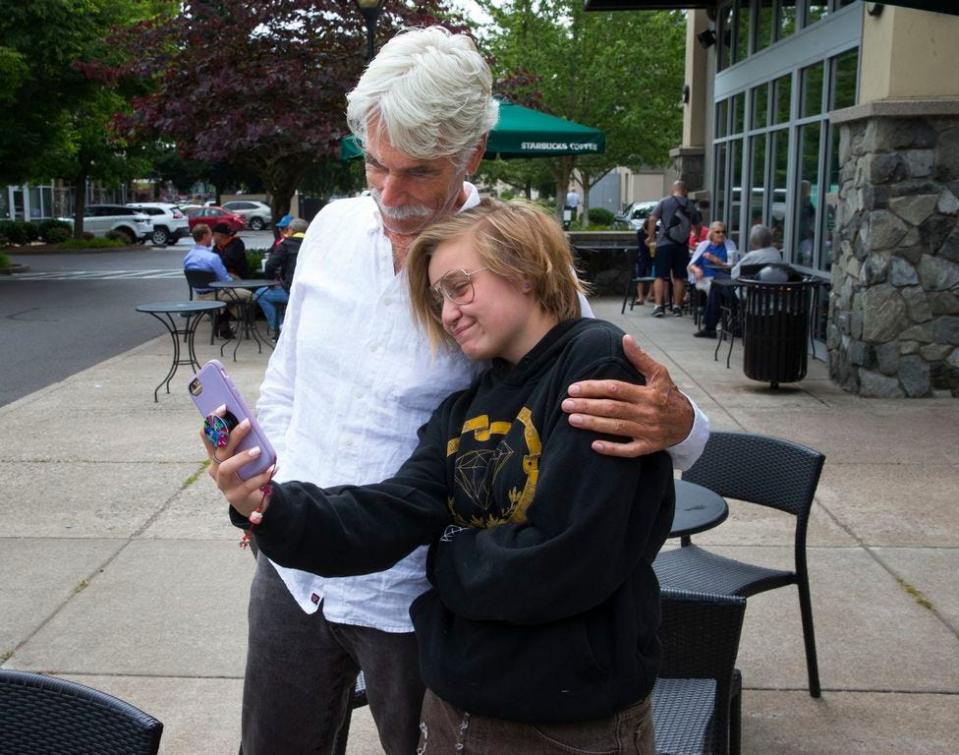 Sam Elliott (left) poses for a photo with fan Sophia Bredbenner, 15, outside a coffee shop in north Eugene.