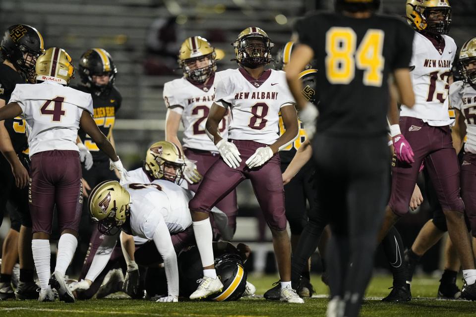 New Albany's Chidi Mabatah (8) celebrates a tackle of Upper Arlington's Jack Ubert during the second half of the Eagles' 20-7 win in a Division I regional semifinal at Westerville Central.