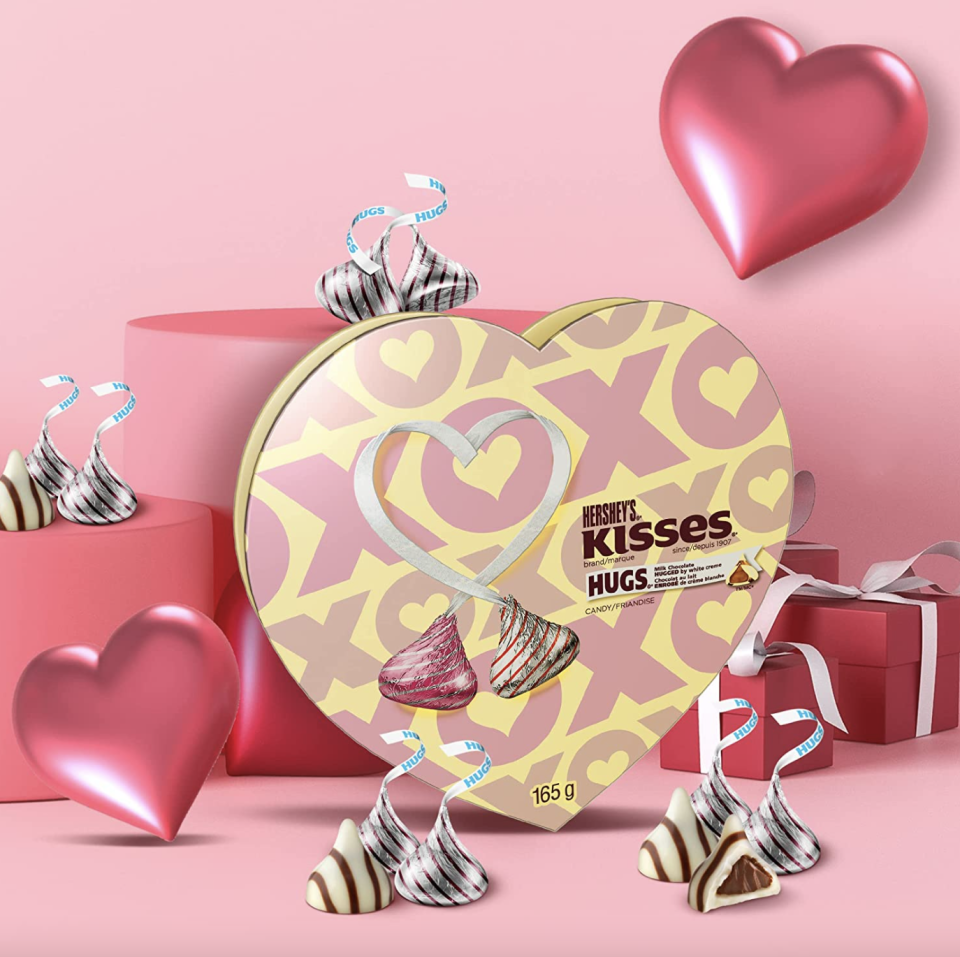 Hershey's Hugs & Kisses Valentine's Day Chocolate Candy in yellow heart box against pink heart background (Photo via Amazon)