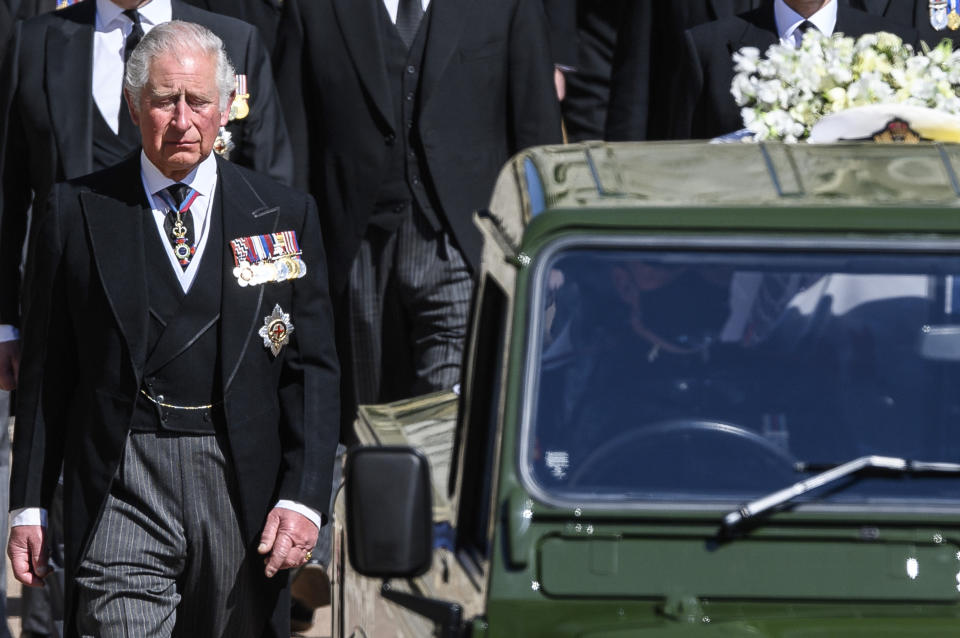 Britain's Prince Charles follows the coffin as it makes it's way past the Round Tower during the funeral of Britain's Prince Philip inside Windsor Castle in Windsor, England Saturday April 17, 2021. (Leon Neal/Pool via AP)