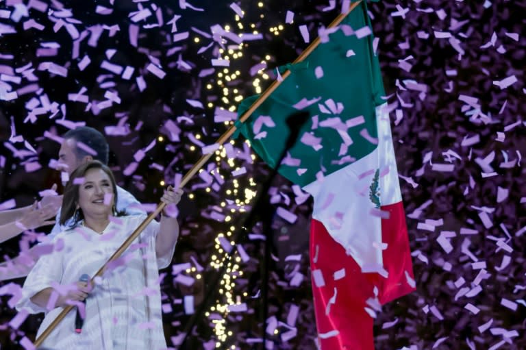 Mexican opposition presidential candidate Xochitl Galvez, polling in second place on the eve of elections, waves the national flag during a campaign rally (Julio Cesar AGUILAR)