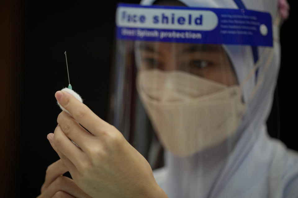 A Nurse prepares a dose of the Pfizer vaccine against the coronavirus disease (COVID-19) for a secondary school student at a vaccine center in Shah Alam, Malaysia, Monday, Sept. 20, 2021. (AP Photo/Vincent Thian)