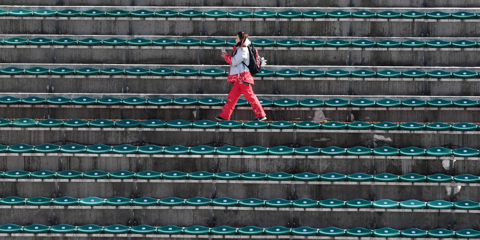 <p>A volunteer walks between empty spectators’ seats at the Alpensia ski jumping center ahead of the PyeongChang 2018 Winter Olympic Games in Pyeongchang on February 8, 2018. (Christof Stache/AFP/Getty Images) </p>