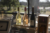 Wine bottles sit in a boutique shop in Le Cannet-des-Maures, in the Provence region, Thursday Oct. 10, 2019. European producers of premium specialty agricultural products like French wine, are facing a U.S. tariff hike on Friday, with dollars 7.5 billion duties on a range of European goods approved by the World Trade Organization for illegal EU subsidies to aviation giant Airbus.(AP Photo/Daniel Cole)