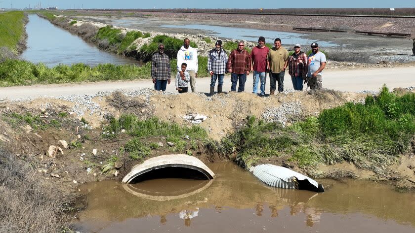 Allensworth, CA, Saturday, March 18, 2023 - Allensworth residents pose for a photo next to a levy they worked to fortify instead of waiting for government agencies to prevent floodwaters from inundating their community. (Robert Gauthier/Los Angeles Times)
