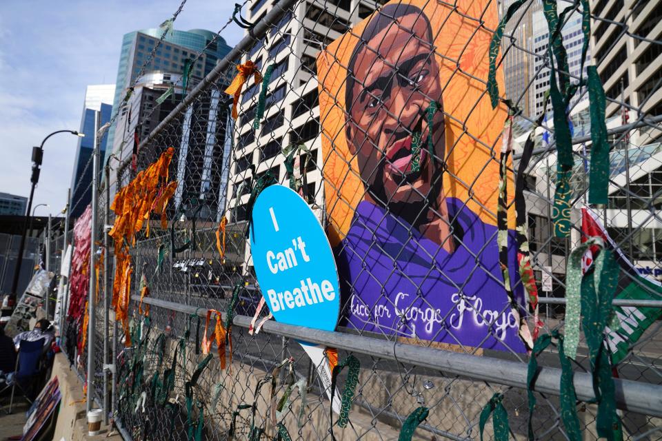 A picture of George Floyd hangs on a fence outside the Hennepin County Government Center, Tuesday, March 30, 2021, in Minneapolis where the trial for former Minneapolis police officer Derek Chauvin continues. Chauvin is charged with murder in the death of Floyd during an arrest last May in Minneapolis.