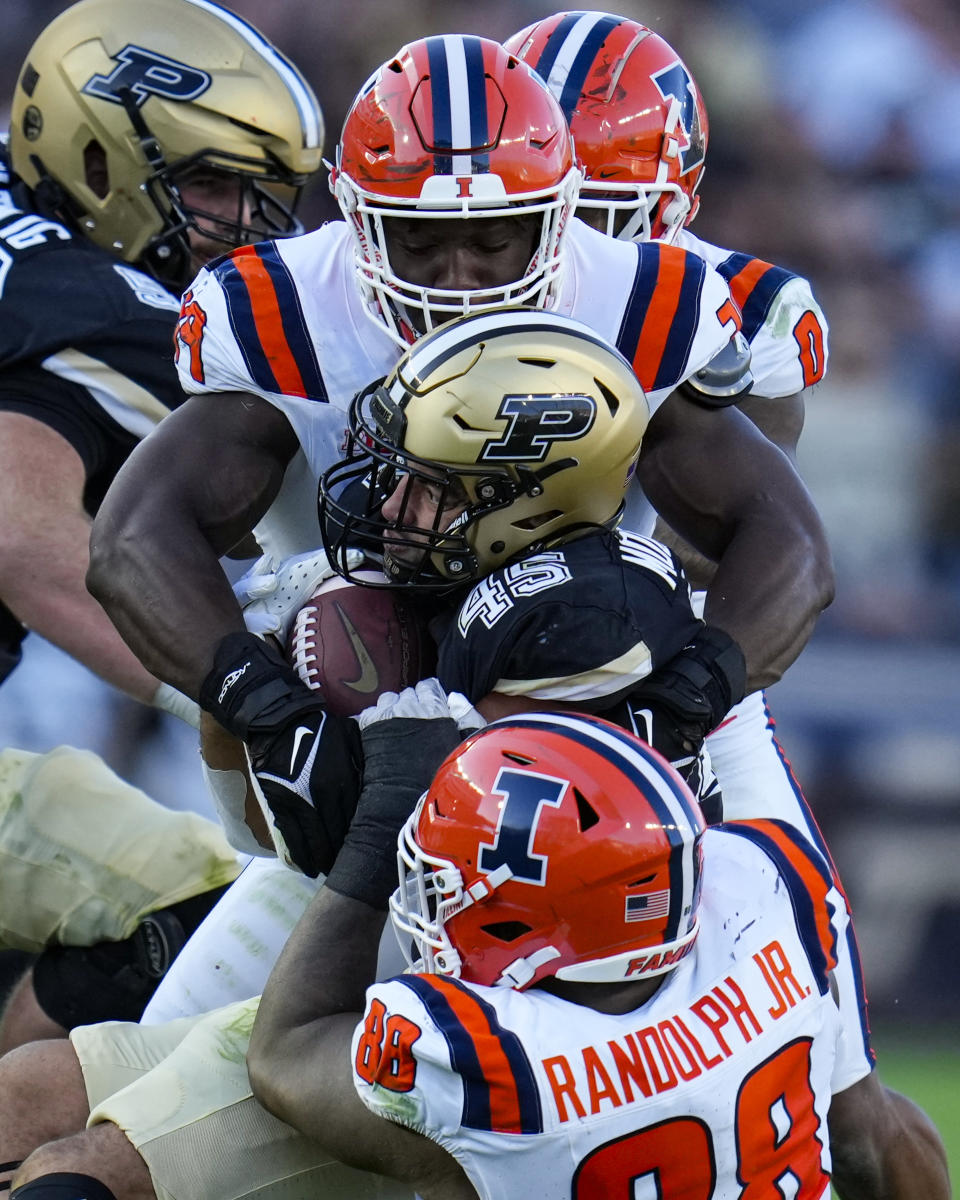 Purdue running back Devin Mockobee (45) is tackled by Illinois linebacker Kenenna Odeluga, top, and defensive lineman Keith Randolph Jr. (88) during the second half of an NCAA college football game in West Lafayette, Ind., Saturday, Sept. 30, 2023. (AP Photo/Michael Conroy)