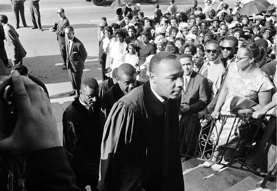 <p>Civil rights leader Rev. Dr. Martin Luther King Jr. is followed by Rev. Fred Shuttlesworth, left, and Ralph Abernathy as they attend funeral services at the Sixth Avenue Baptist Church for three of the four black girls killed in a church explosion in Birmingham, Ala., Sept. 18, 1963. (AP Photo) </p>