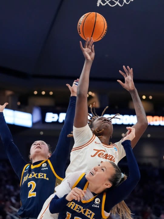 Texas forward DeYona Gaston, center, reaches over Drexel guard Grace O’Neill, front, for a rebound during the first half of a first-round college basketball game in the women’s NCAA Tournament in Austin, Texas, Friday, March 22, 2024. (AP Photo/Eric Gay)