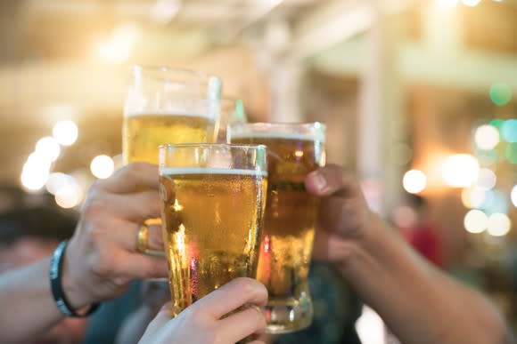 Three friends drink beer together.