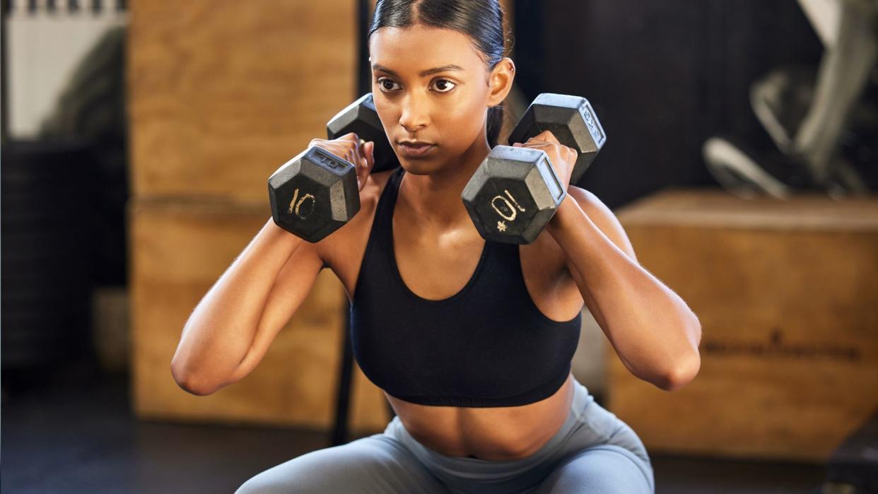  A woman doing dumbbell squats. 