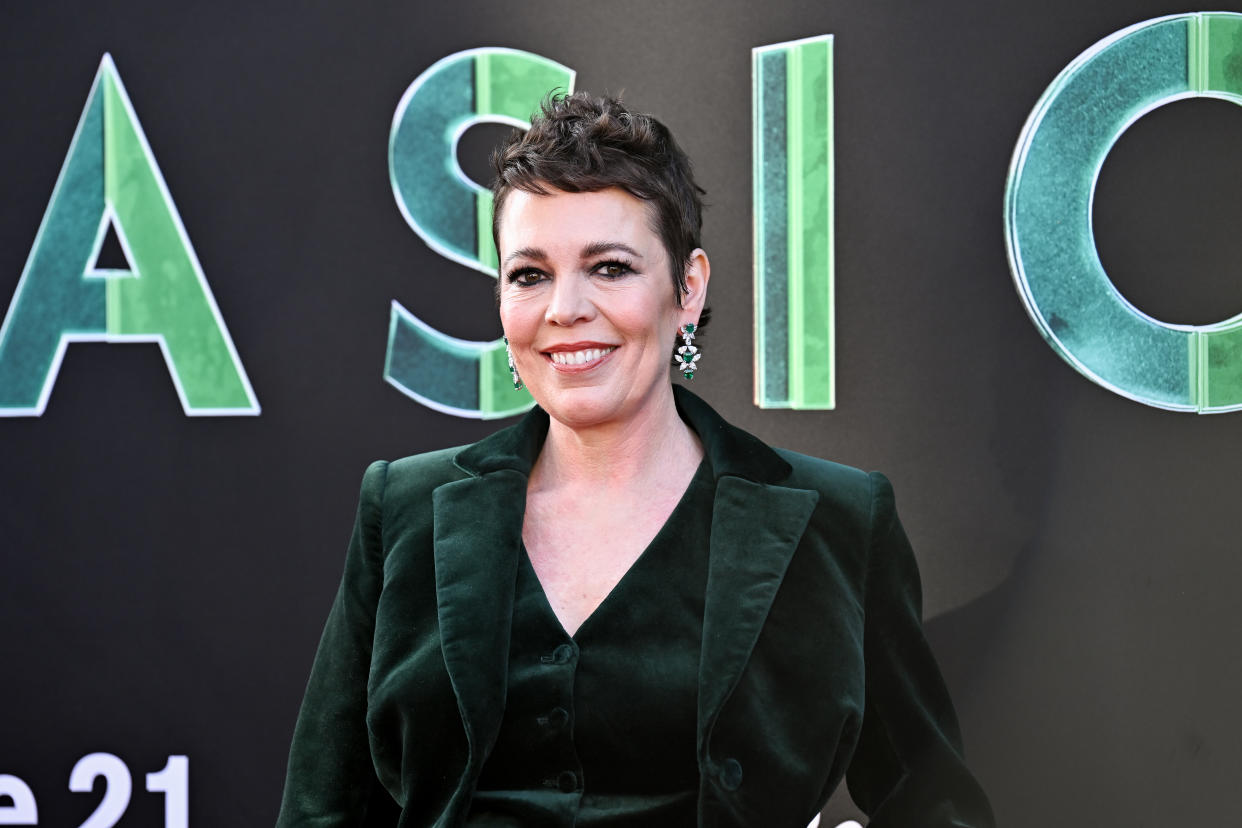 Olivia Colman smiles as she poses on the red carpet 