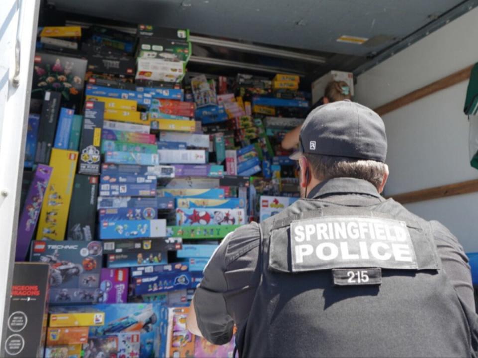 A police officer in Eugene, Oregon, stares at a container filled with Lego sets, which police allege were stolen then sold to a local toy store called Brick Builders. (Springfield Police Department)